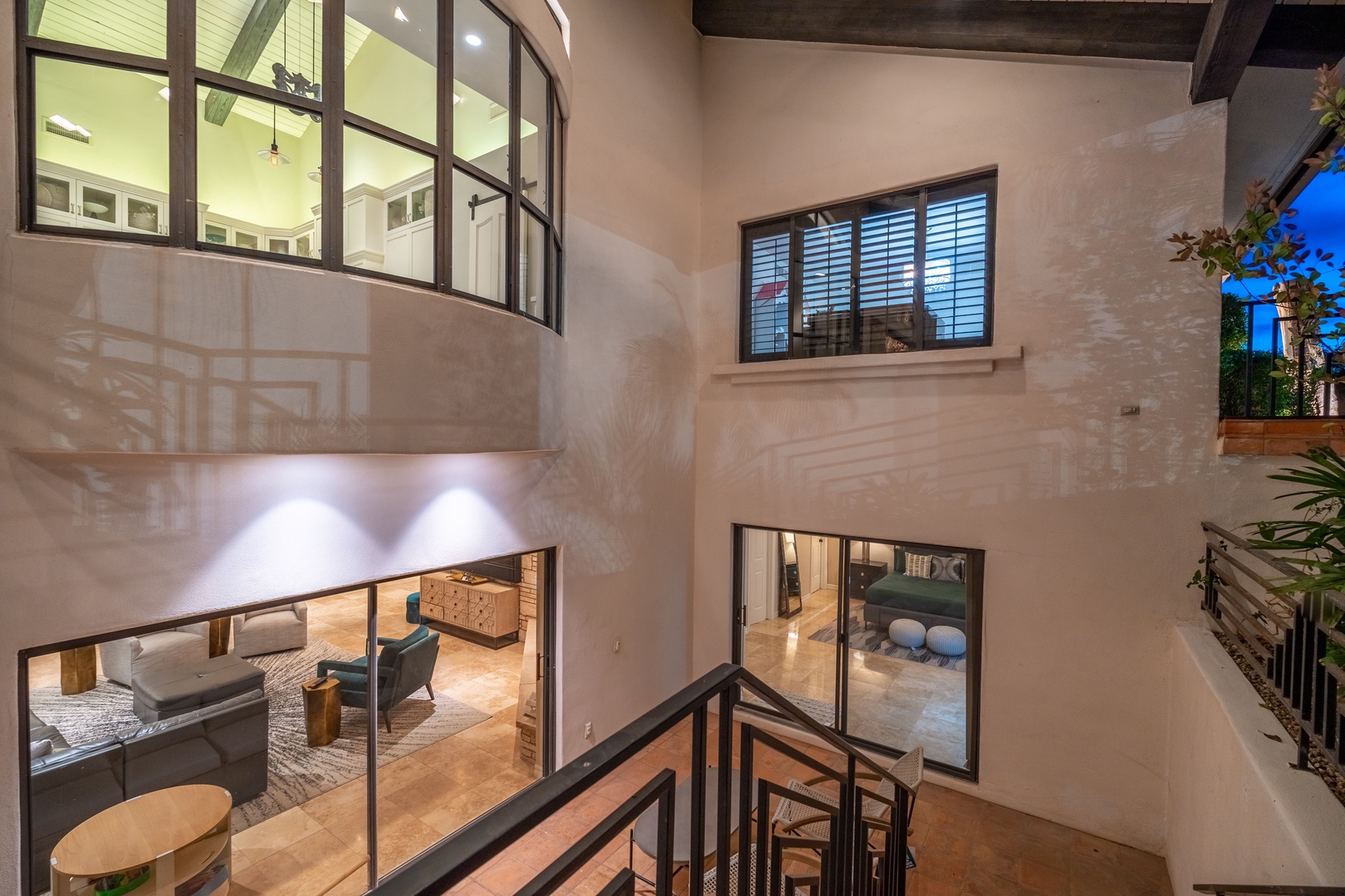 Soaring ceilings and walls of windows create a luminous sanctuary where natural light pours through steel-framed glass, connecting your modern living spaces across two inviting levels of contemporary comfort.