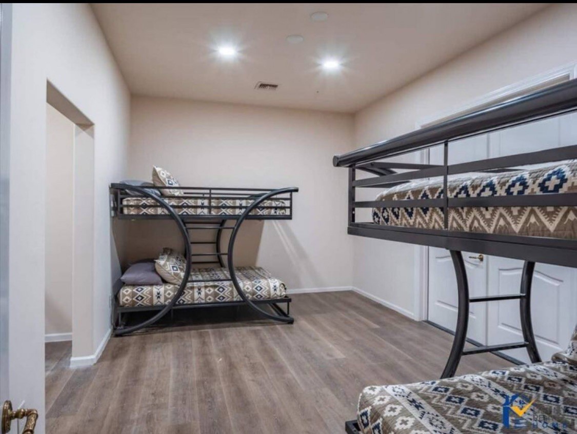 Sleep soundly in this cozy bunk room where geometric patterns and warm wood floors create your perfect retreat for rest.