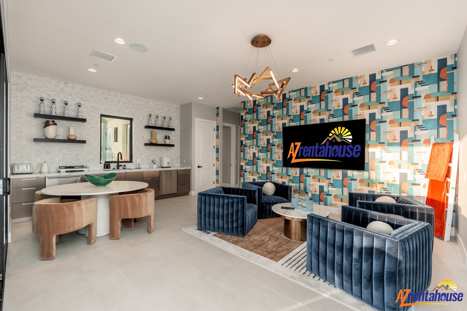 Unwind in your stylish open-concept space featuring bold geometric wallpaper, luxurious navy seating, and a sleek kitchen perfect for entertaining.