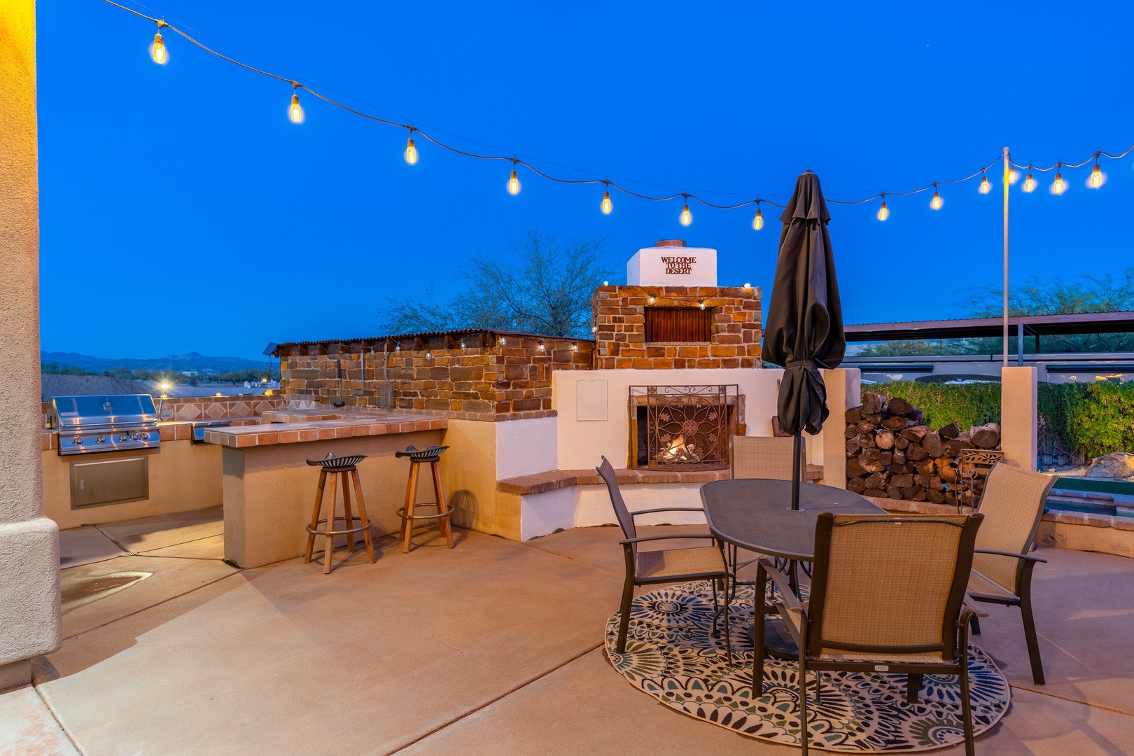 Your private outdoor oasis awaits—grill under twinkling lights by the fireplace, gather around the table for evening meals, and unwind as the desert sky glows above.