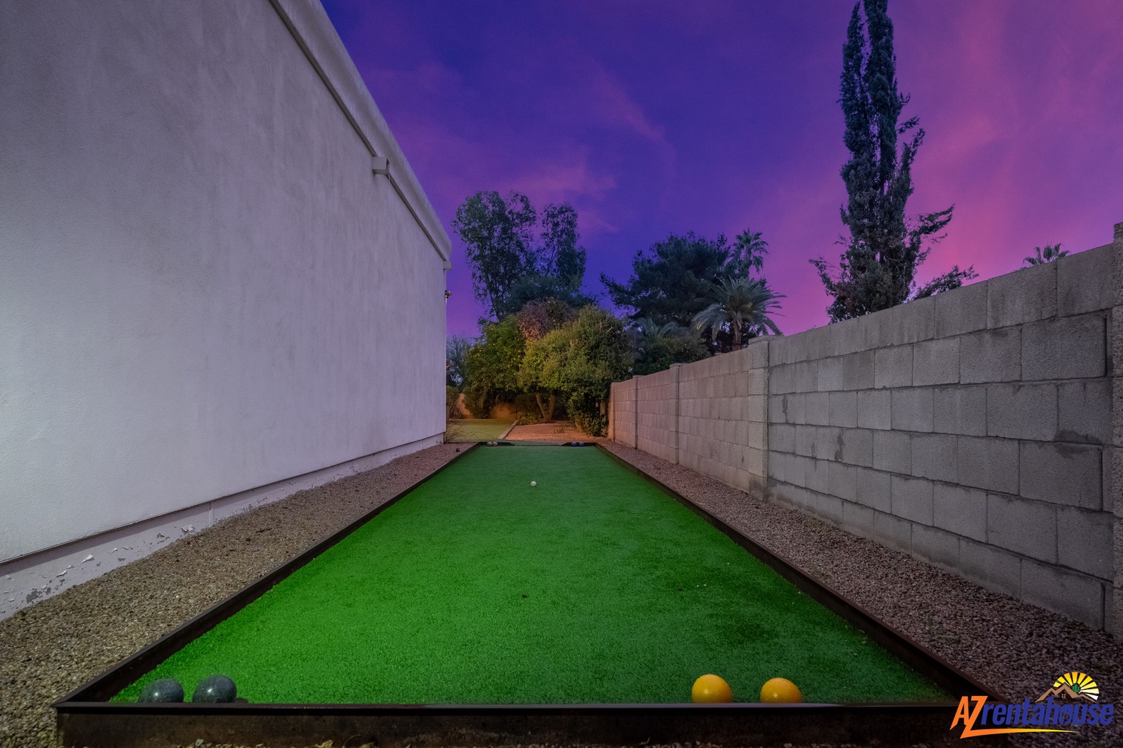 A private bocce ball court under vibrant twilight skies creates the perfect setting for evening games with friends and family.