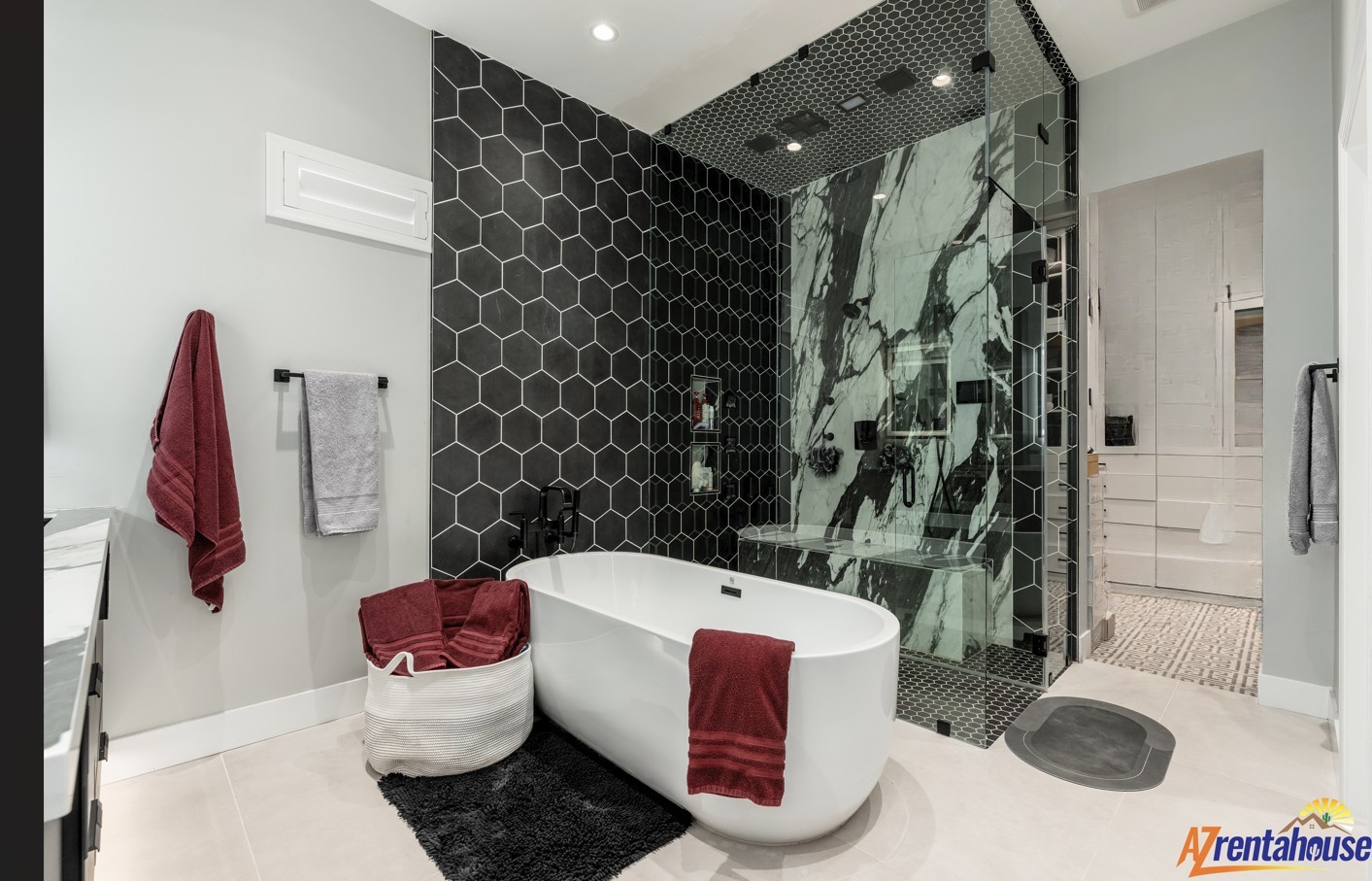 Unwind in your luxurious spa-like bathroom featuring a sleek soaking tub, stunning marble shower, and elegant black hexagon tile accents.
