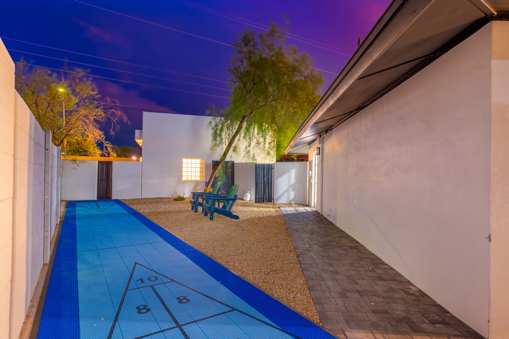 Private courtyard with a striking blue lap pool, perfect for evening swims beneath desert skies. Relax poolside with a desert tree overhead and modern outdoor seating.