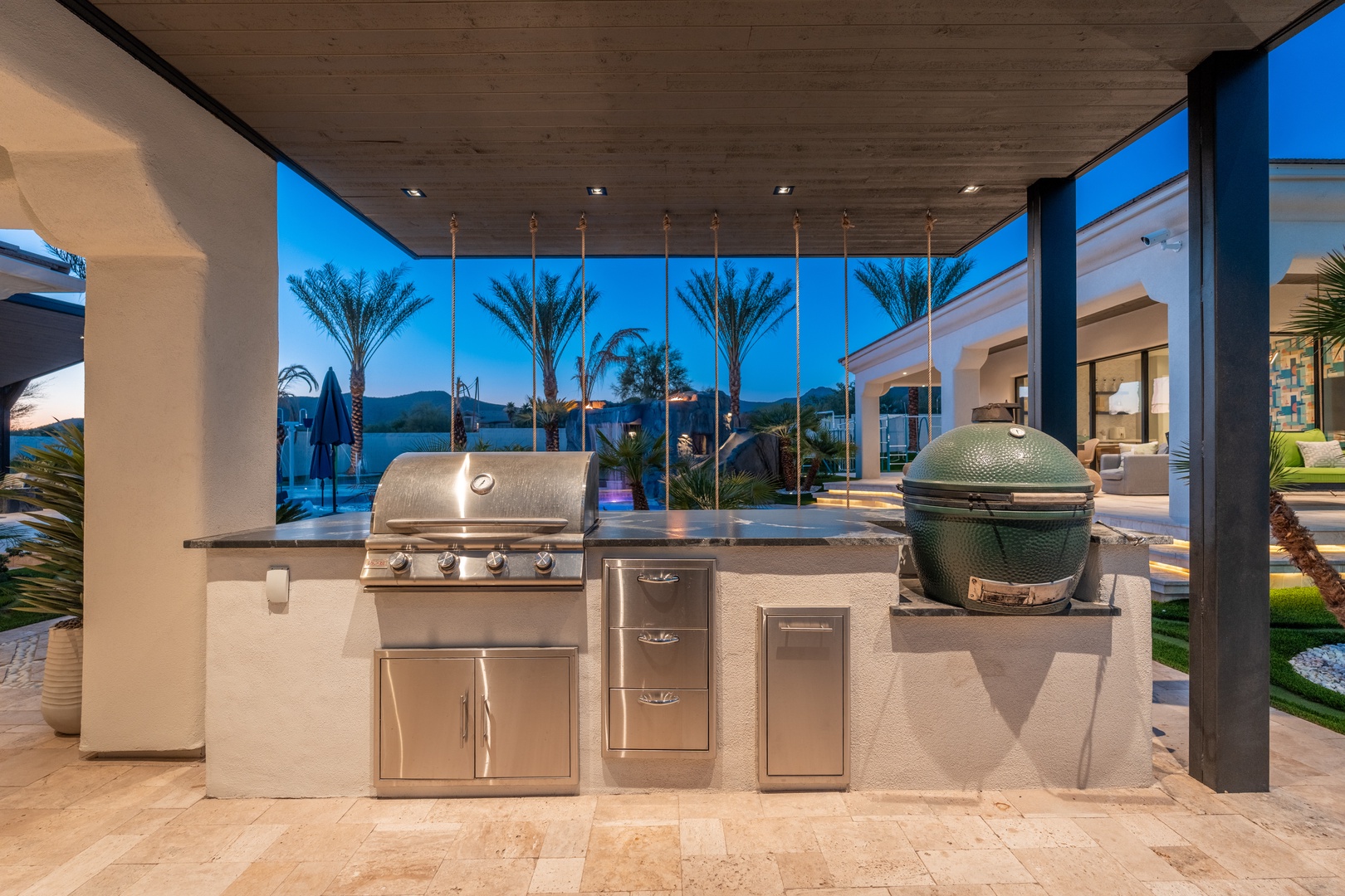 Your private outdoor kitchen awaits with premium grills and serene waterfront views—perfect for sunset cookouts and memorable gatherings under palm trees.