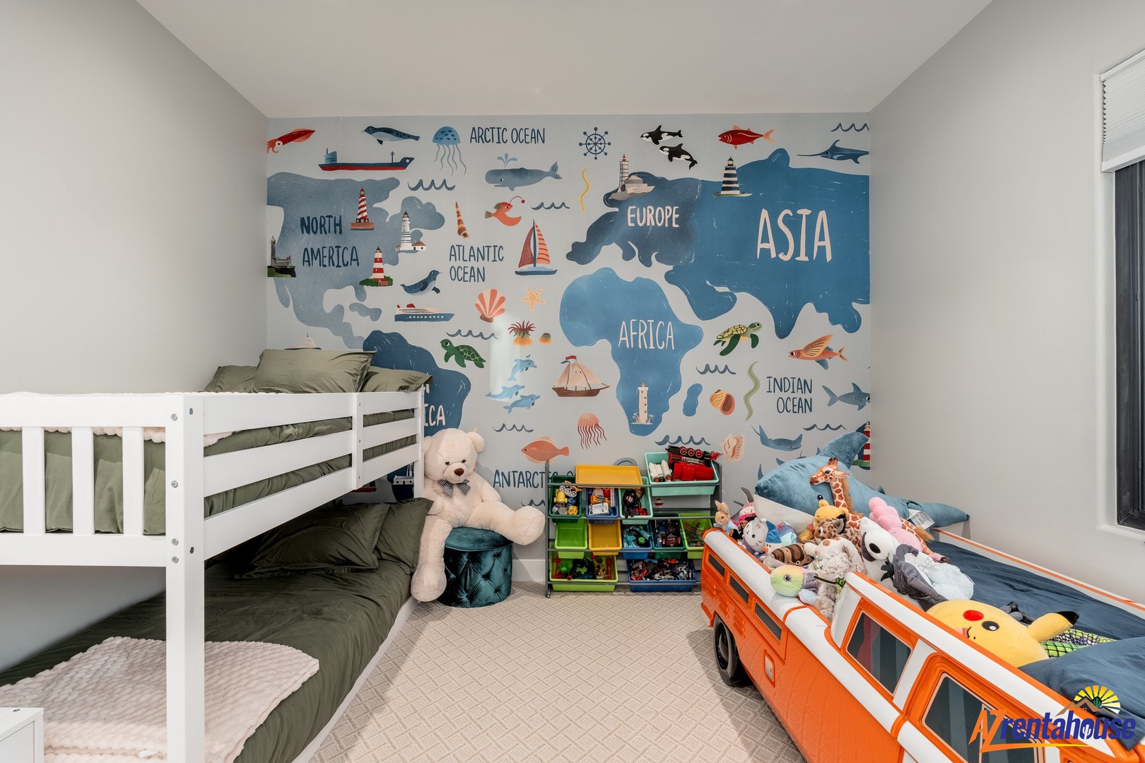 Your little explorers will love this adventure-themed room with bunk beds, world map mural, and plenty of toys for imaginative play.