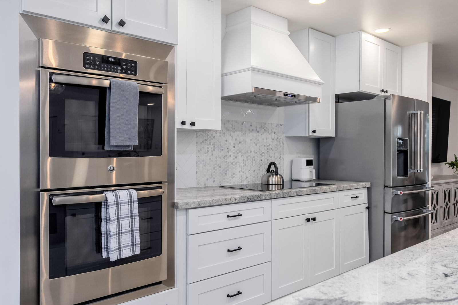 Step into a chef-ready kitchen with gleaming stainless steel appliances, custom white cabinetry, and elegant granite countertops—your culinary retreat awaits.