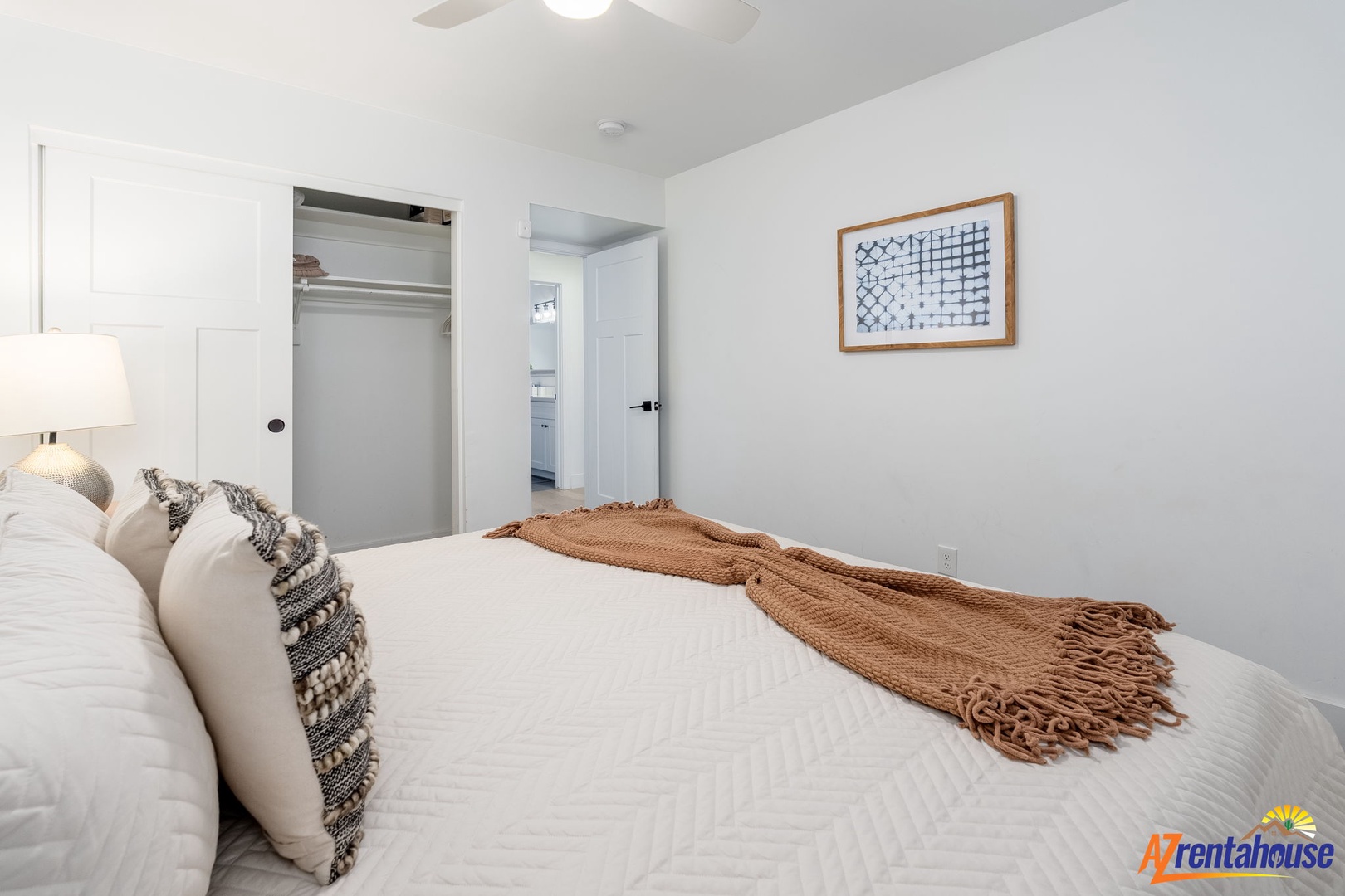 Rest peacefully in your bright, modern bedroom with soft linens and thoughtful touches like cozy throws and artwork.