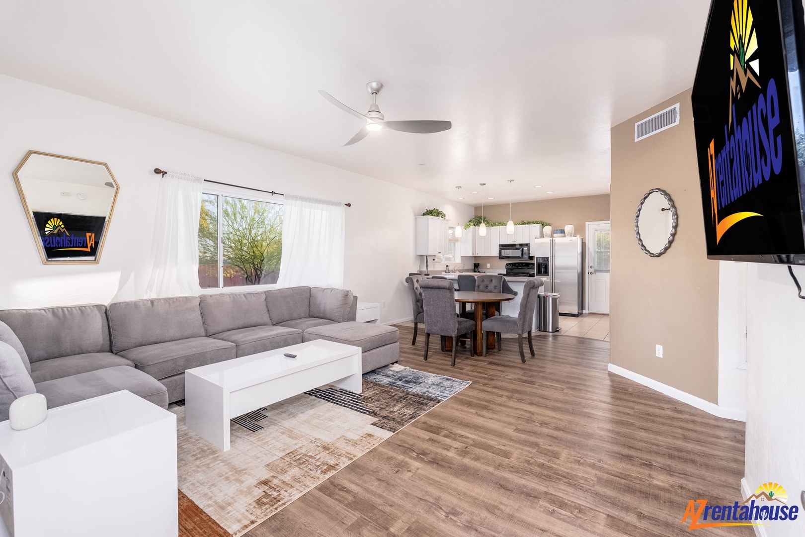 Unwind in your spacious, sunlit living area with plush seating, ceiling fan comfort, and seamless flow to the fully equipped kitchen—perfect for relaxing or gathering with loved ones.