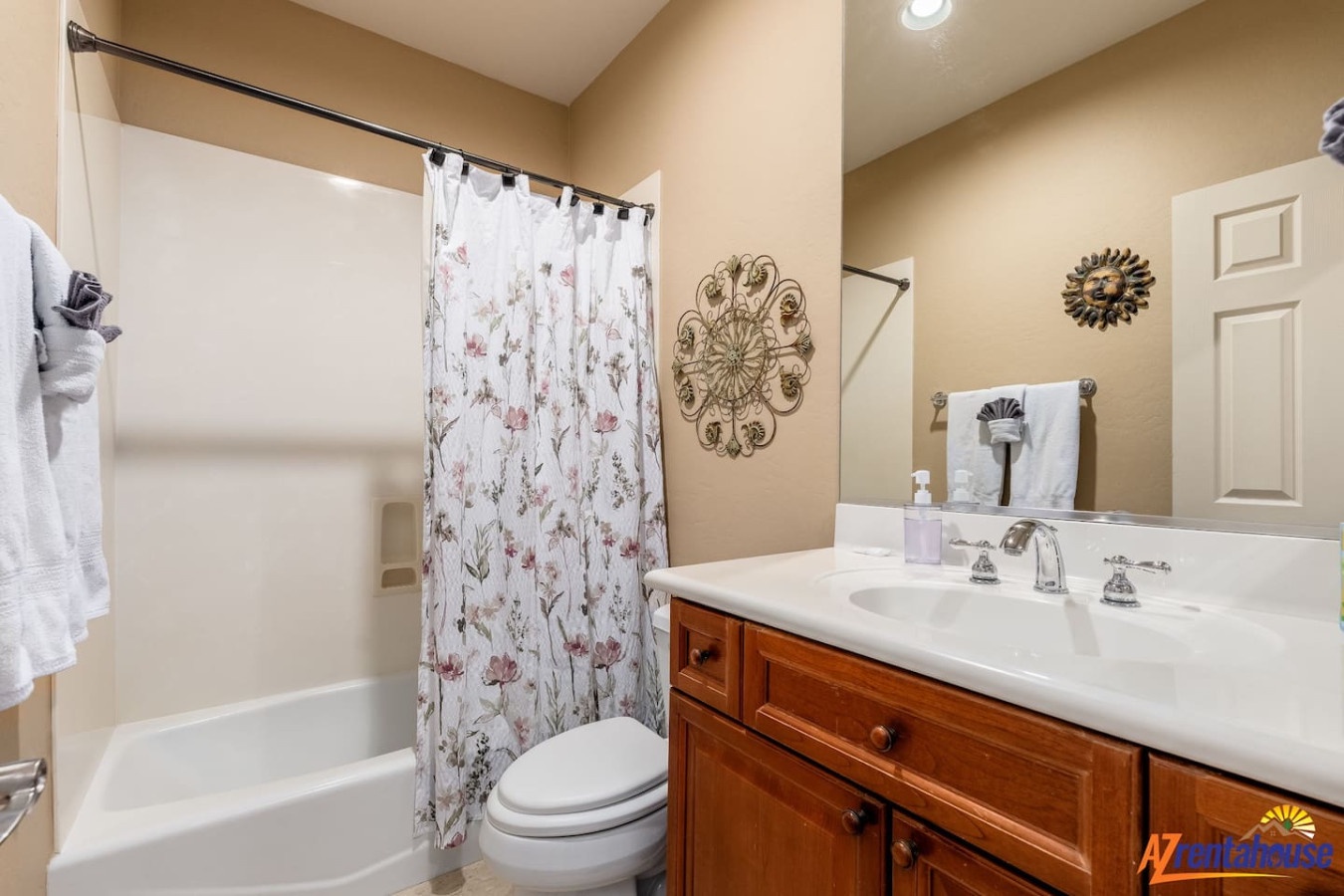 Your private bathroom features a relaxing tub, elegant vanity, and thoughtful touches like fresh towels and charming floral details.