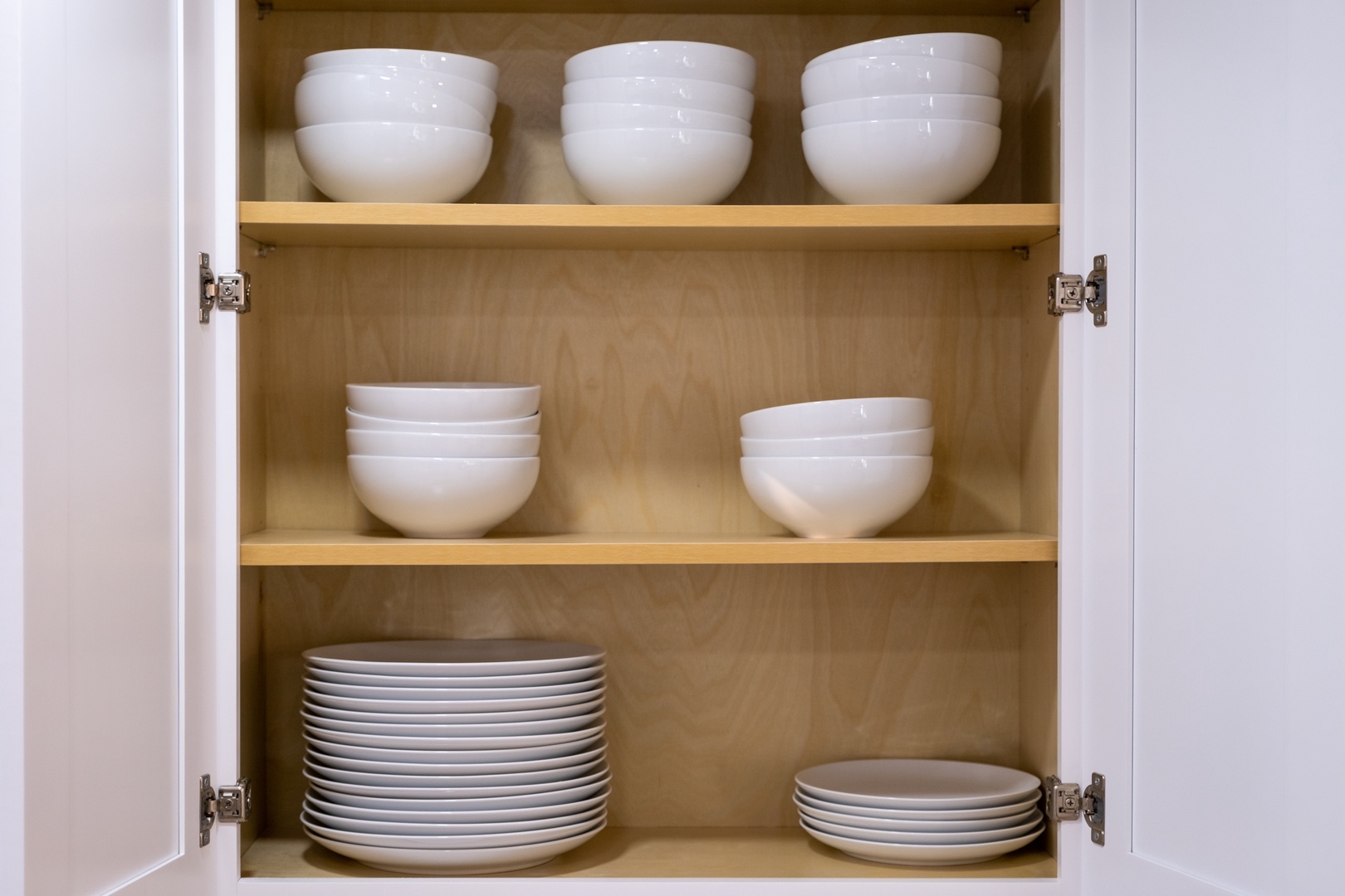 Well-stocked cabinets with neatly arranged dishes and bowls ensure you'll have everything you need to prepare and serve meals during your stay.