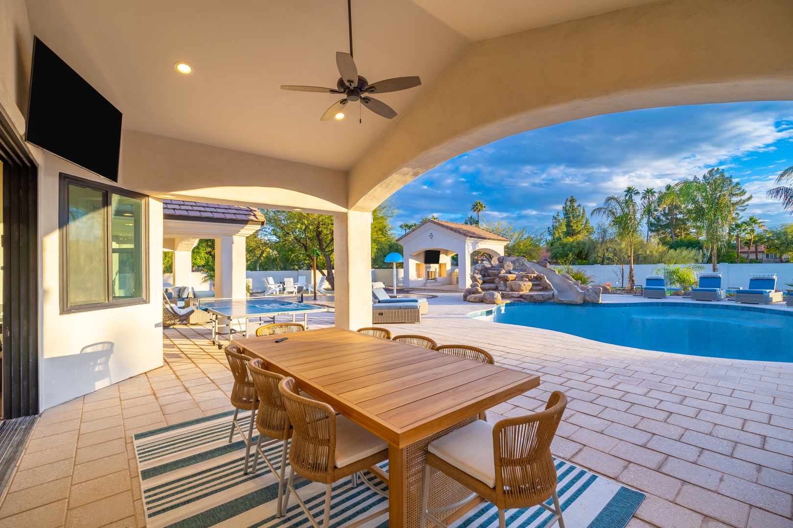 Dine under the covered patio with your resort-style pool just steps away, surrounded by lush palms and mountain views.