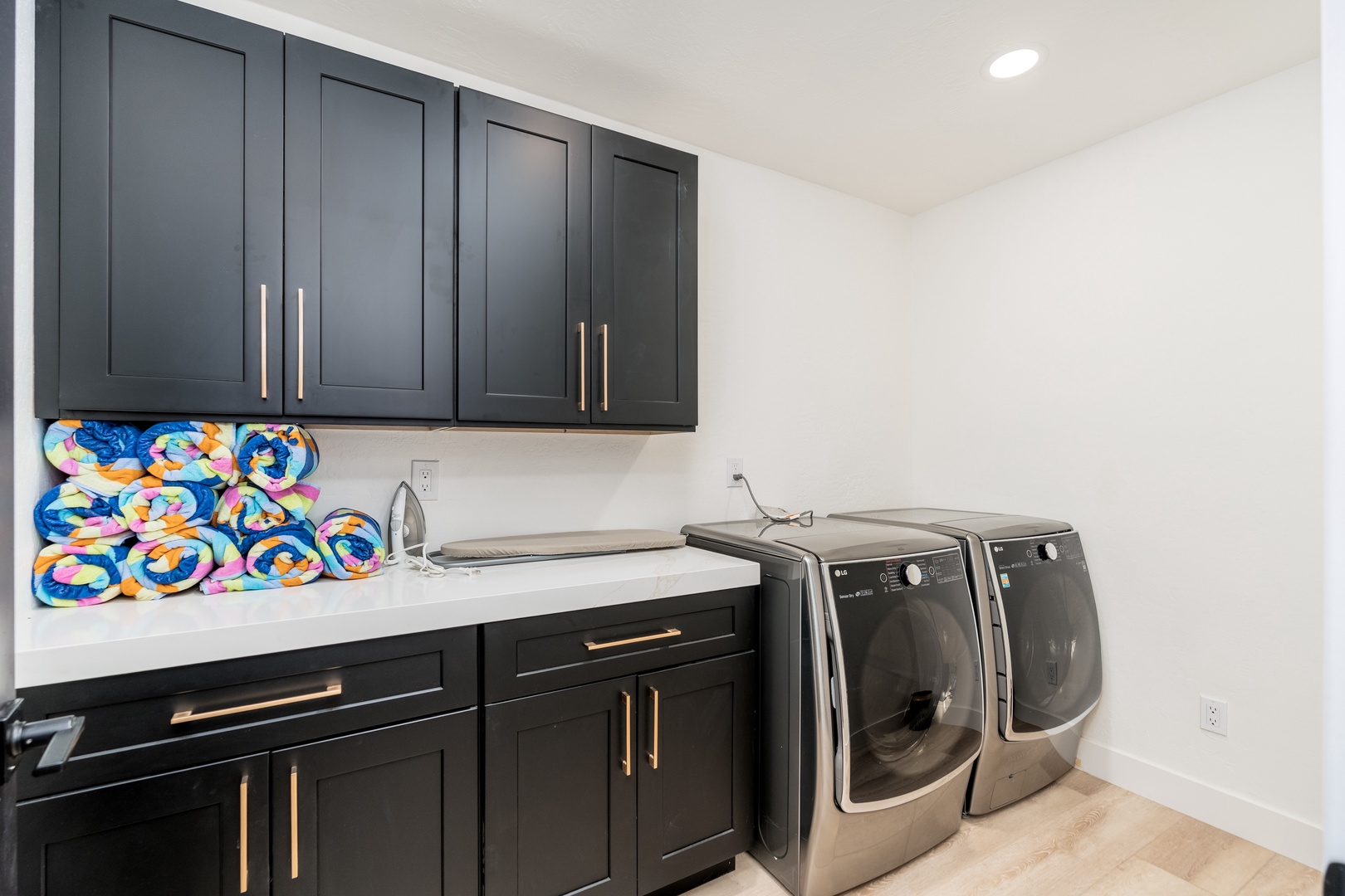 Your dedicated laundry space features modern appliances and sleek cabinetry, making wash day effortless. Bright, organized, and stocked with colorful pool towels for your beach adventures.