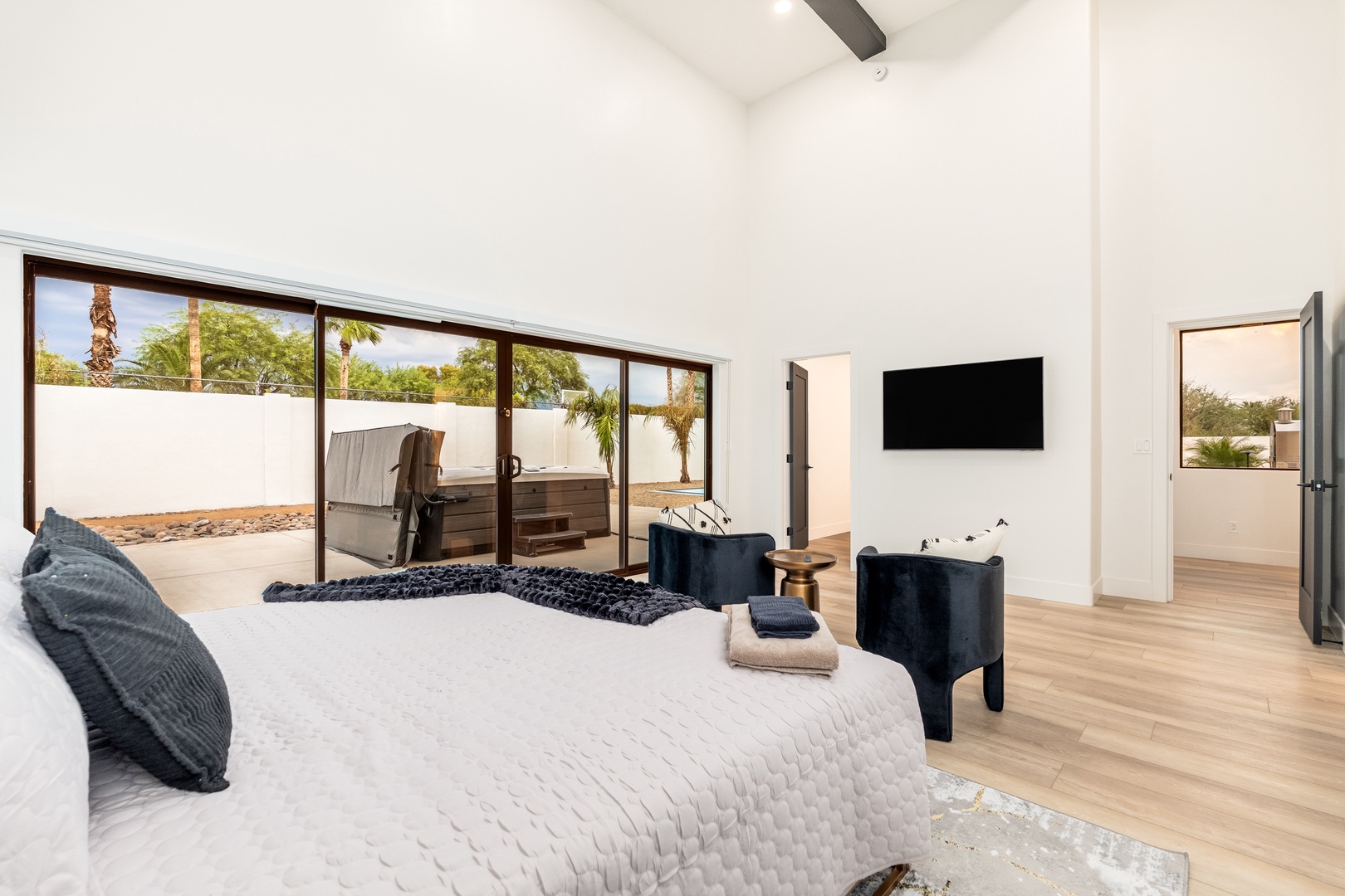 Unwind in your spacious bedroom where vaulted ceilings and warm wood floors create an airy retreat. Step through sliding glass doors to your private patio with a hot tub surrounded by desert palms.