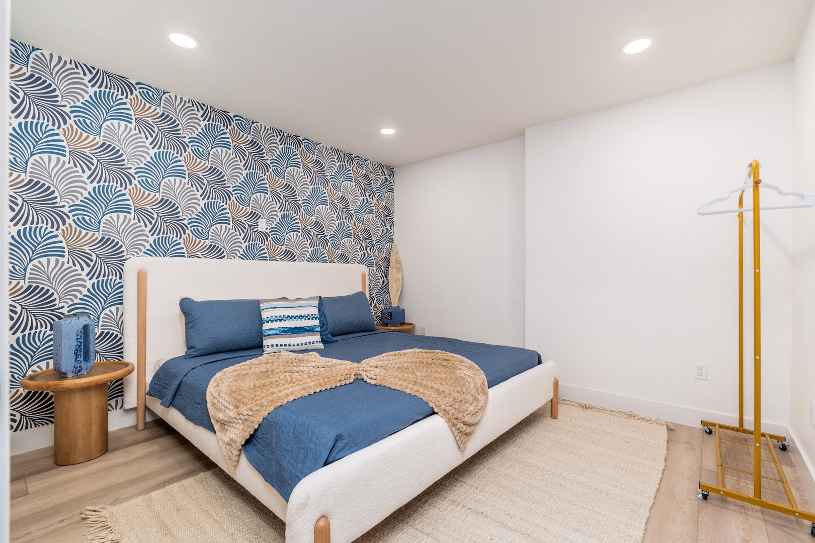 Sink into crisp blue linens and let the calming wave-patterned accent wall wash over you as you unwind in your serene coastal-inspired retreat.