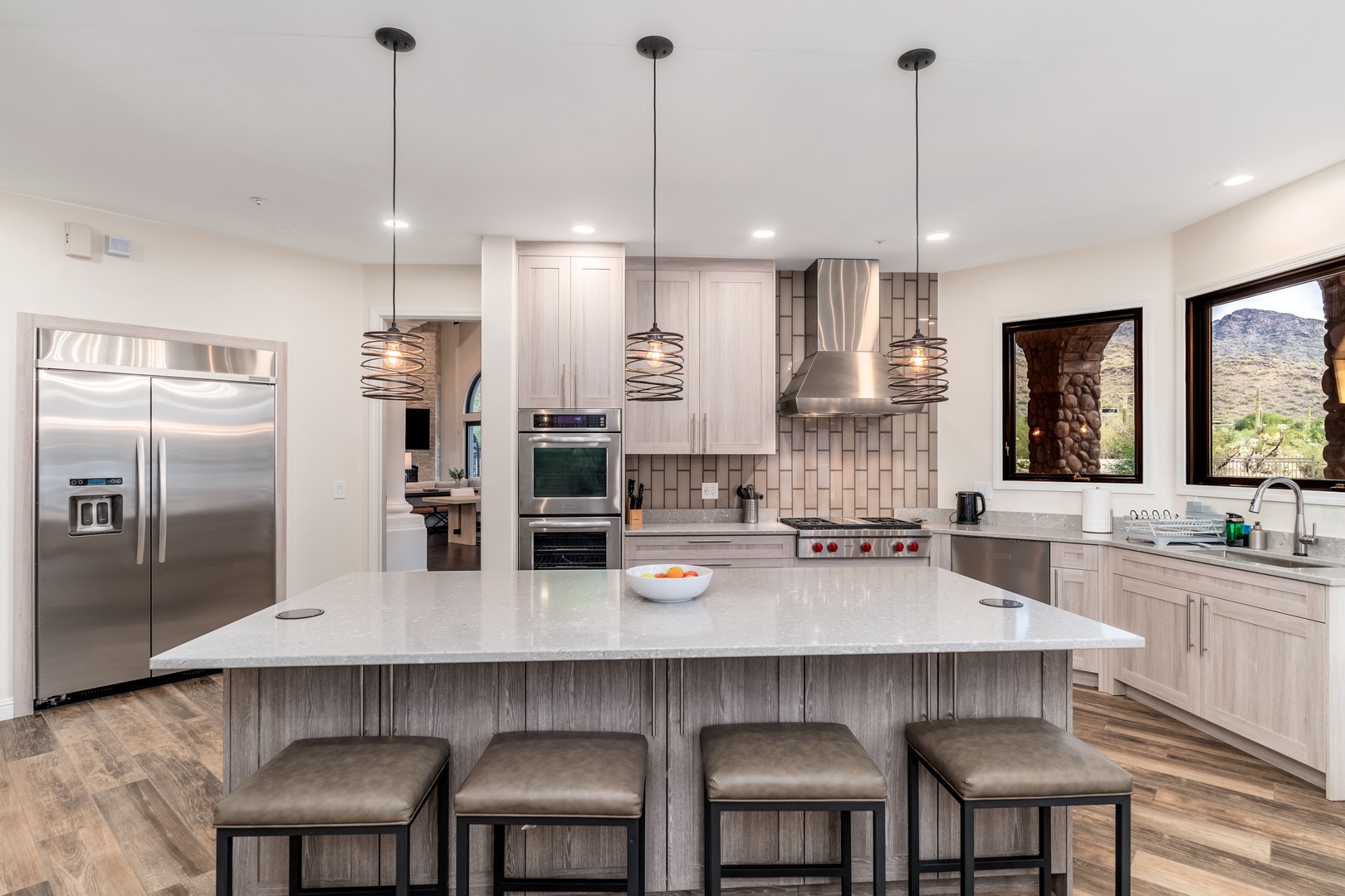 Picture yourself preparing meals in this spacious, fully equipped kitchen, bathed in natural light from large windows that frame stunning mountain views. Gather with loved ones at the expansive island, blending style and function for your perfect getaway.