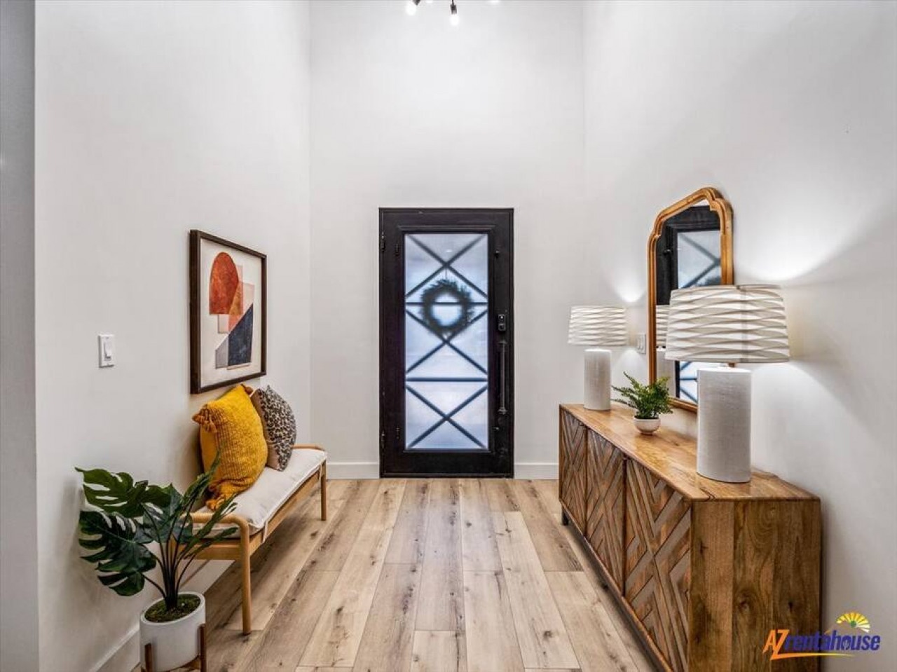 Step into your stylish entryway featuring warm wood accents, modern art, and thoughtful touches that welcome you home.