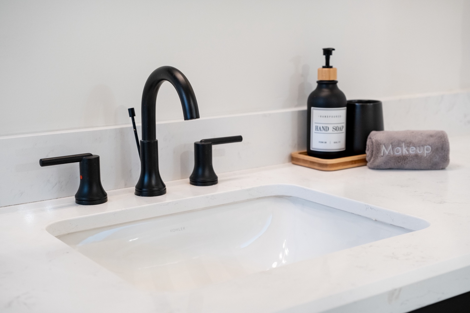 Modern elegance meets everyday comfort at your private sink, where sleek black fixtures and thoughtful touches like artisan hand soap create a spa-like experience for your morning routine.