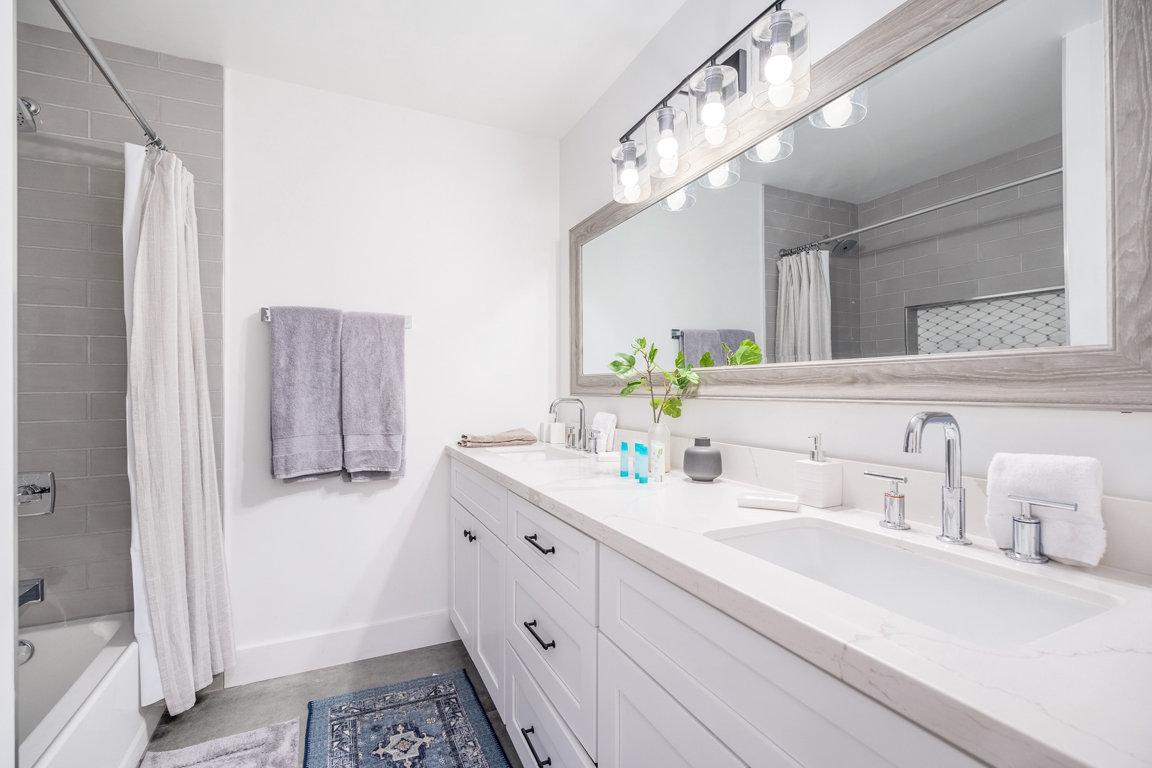 Unwind in your bright, modern bathroom with dual sinks, a refreshing tub-shower combo, and plush towels waiting for you after a long day of exploring.