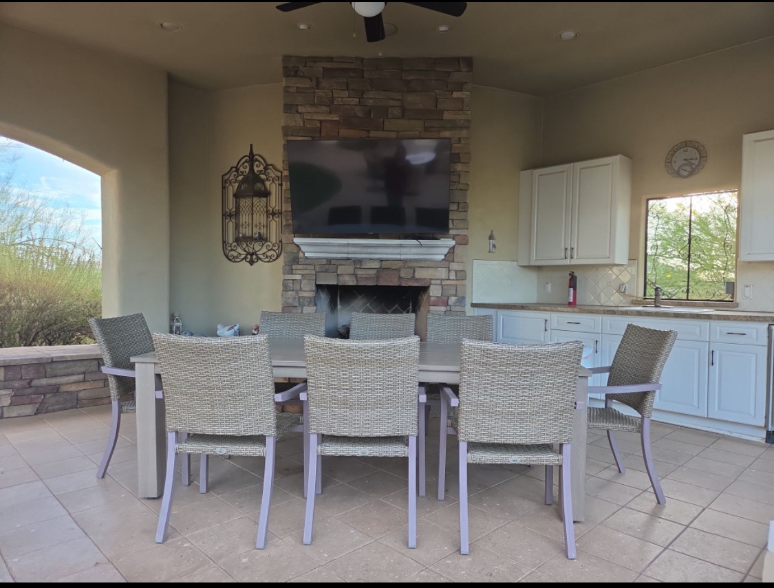 Your private outdoor oasis features a covered patio with dining for eight, a cozy stone fireplace, full outdoor kitchen, and stunning desert views—perfect for memorable meals and evenings under the stars.
