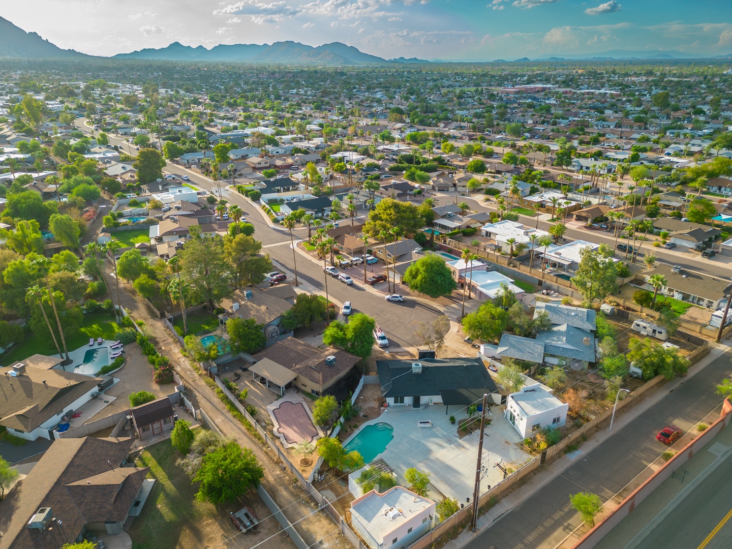 Aerial view of a residential neighborhood with mountain backdrop, showcasing the property's desert setting and surrounding area.