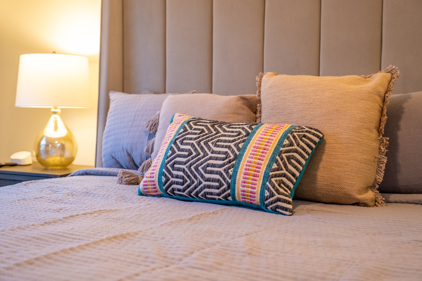 Sink into plush bedding piled high with decorative pillows as warm light from your bedside lamp creates the perfect retreat after a day of exploring.