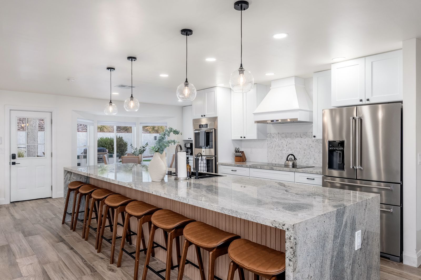 A bright, modern kitchen with stunning marble countertops and custom lighting invites you to gather, cook, and create memories together.