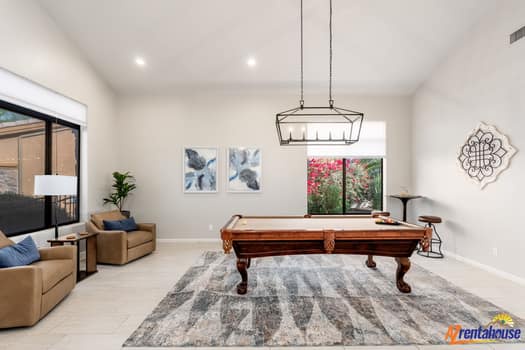 Unwind in your spacious game room with a beautiful pool table, perfect for friendly matches under elegant lighting.