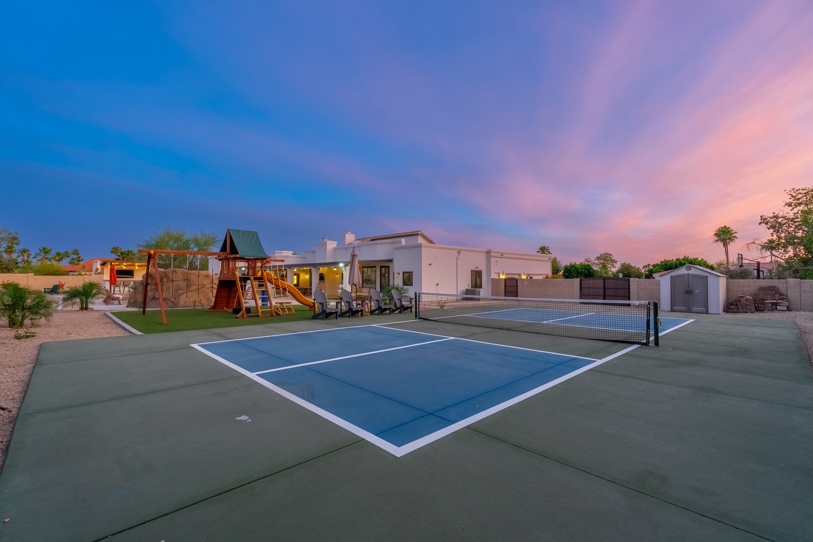 The property features a private tennis court and colorful playground, offering fun for all ages beneath stunning Arizona sunsets.