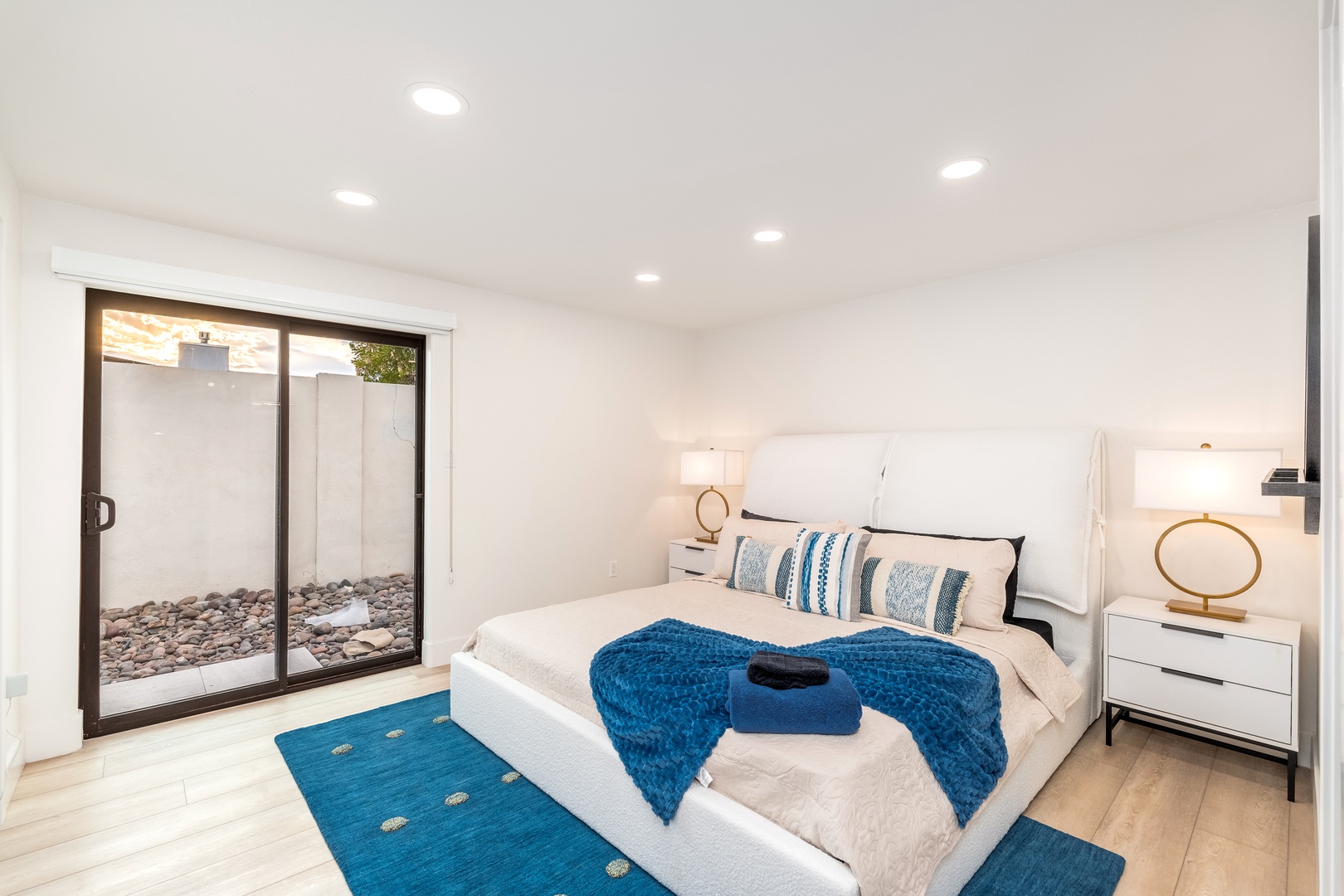 Step into your serene retreat with a plush king bed, modern lighting, and private courtyard access. Unwind in crisp linens with coastal-inspired accents framing your restful escape.
