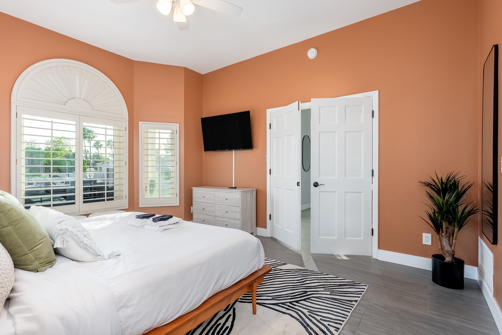 Your sunlit retreat features warm terracotta walls, crisp white linens, and a peaceful ambiance. Natural light pours through elegant shutters, while modern comforts like streaming TV and sleek furnishings await.