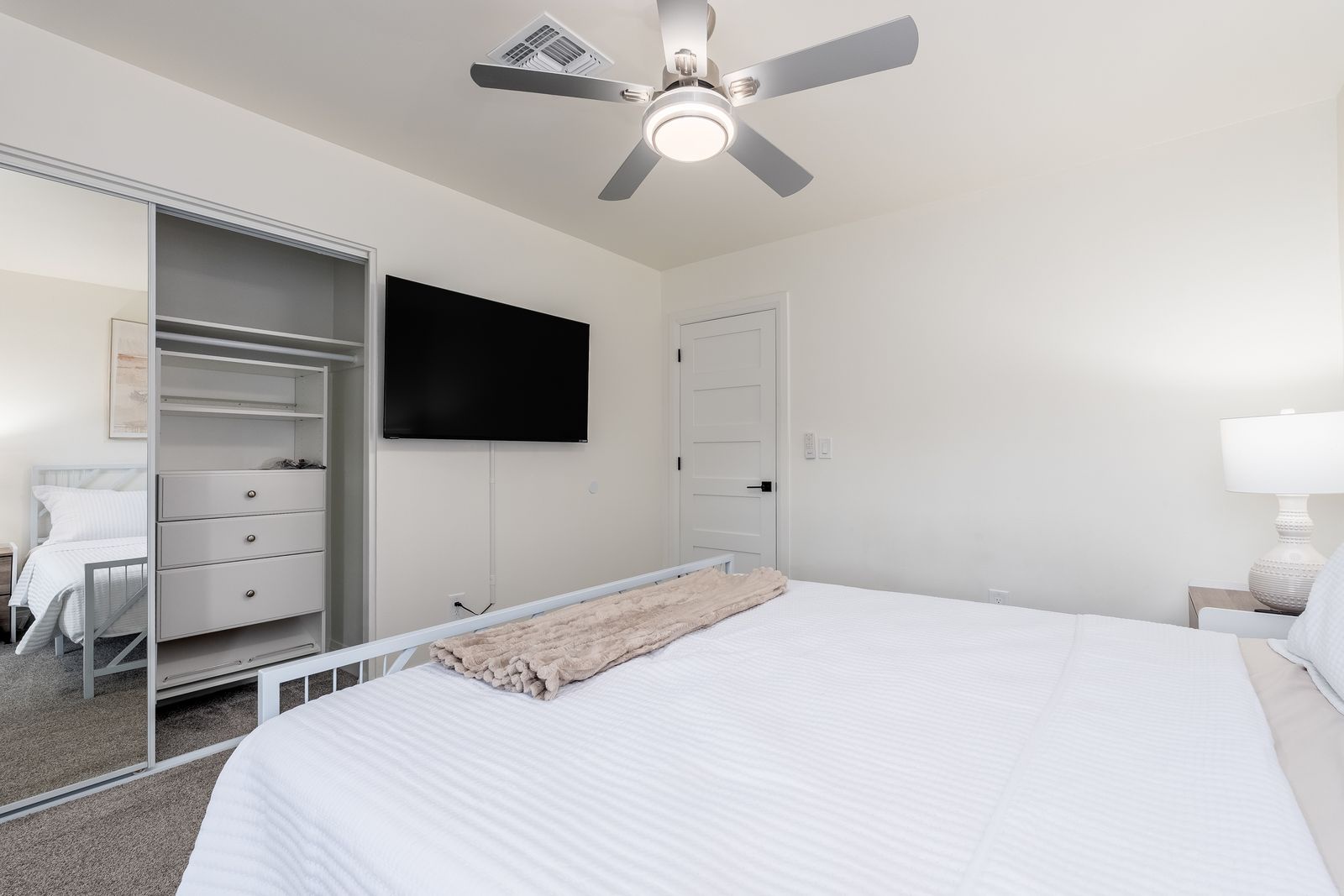 Sink into crisp white linens in your serene bedroom, complete with a ceiling fan and flat-screen TV for your comfort.