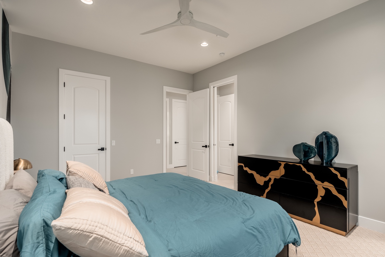 Unwind in your serene retreat with soft linens, a gentle ceiling fan, and calming decor. Your restful escape awaits in this thoughtfully designed space.