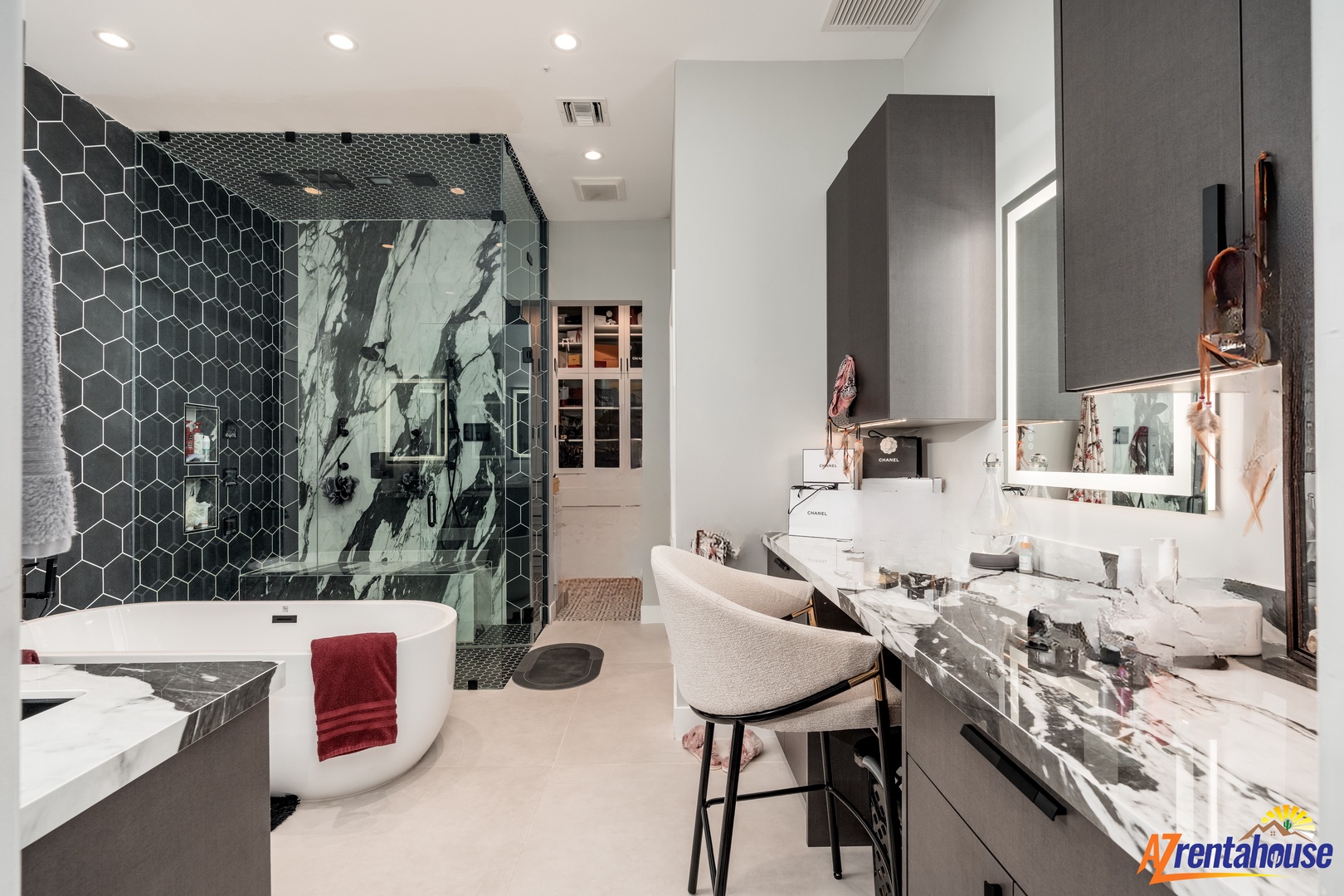 Unwind in your marble-clad sanctuary featuring a luxurious soaking tub, rainfall shower, and elegant vanity seating area.