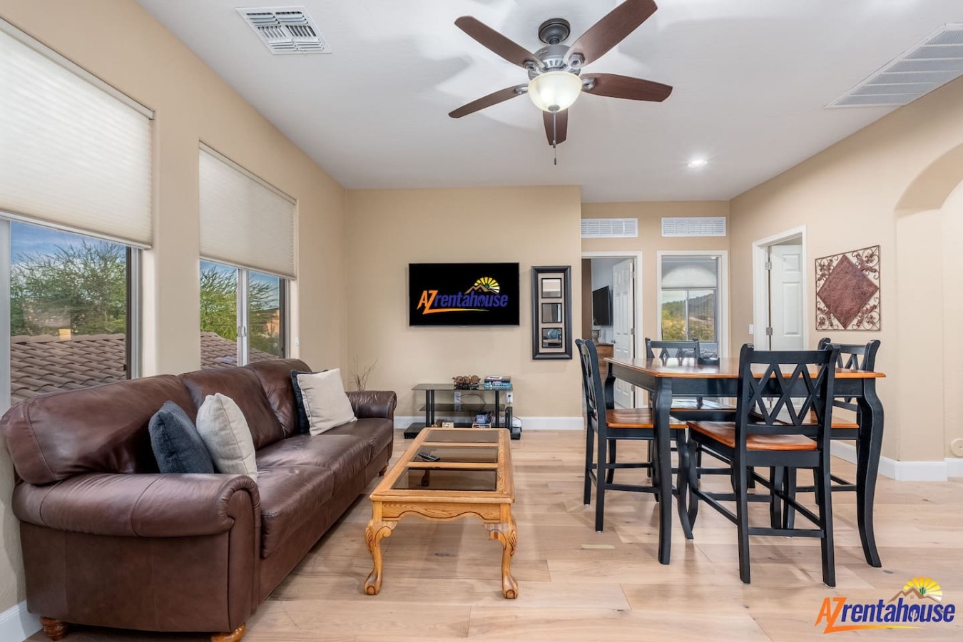 Relax in your spacious open-concept living area with plush leather seating, modern dining space, and desert views through large windows.