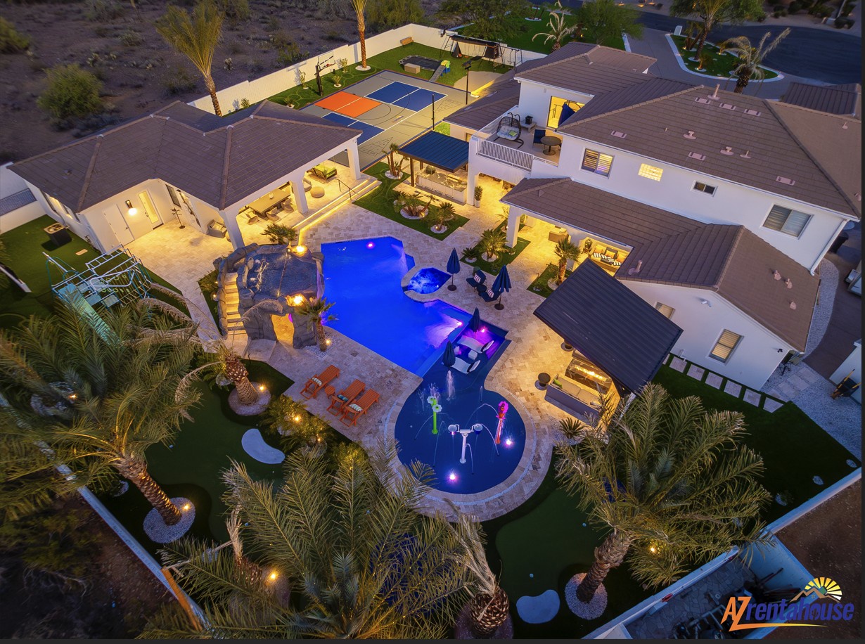 Stunning aerial view reveals an expansive luxury estate with resort-style pool, spa, outdoor kitchen, and basketball court.