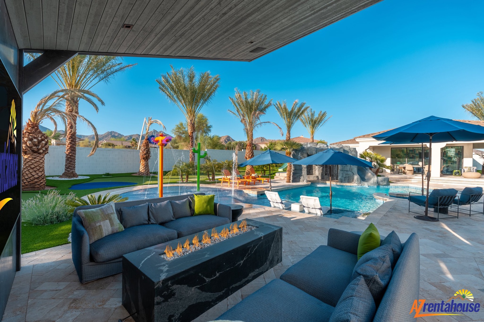Relax in your private poolside paradise with cozy seating around the fire table while kids splash in the water playground.