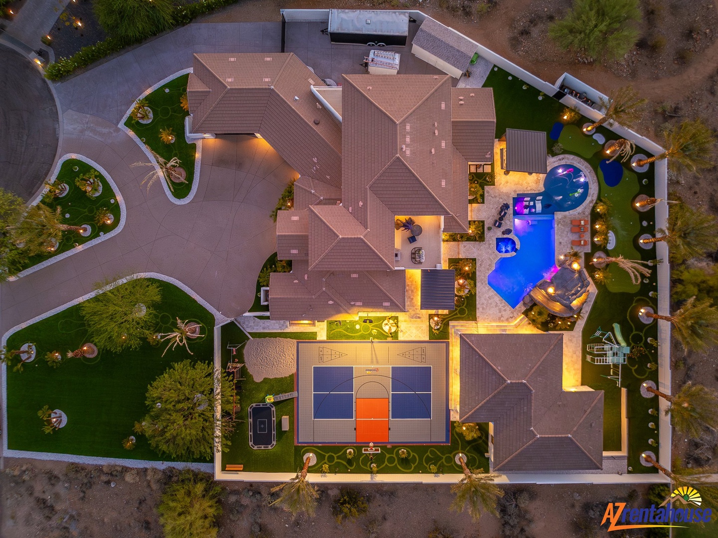 Stunning aerial view of this luxury desert estate showcasing the expansive property layout, championship tennis court, and resort-style pool area.