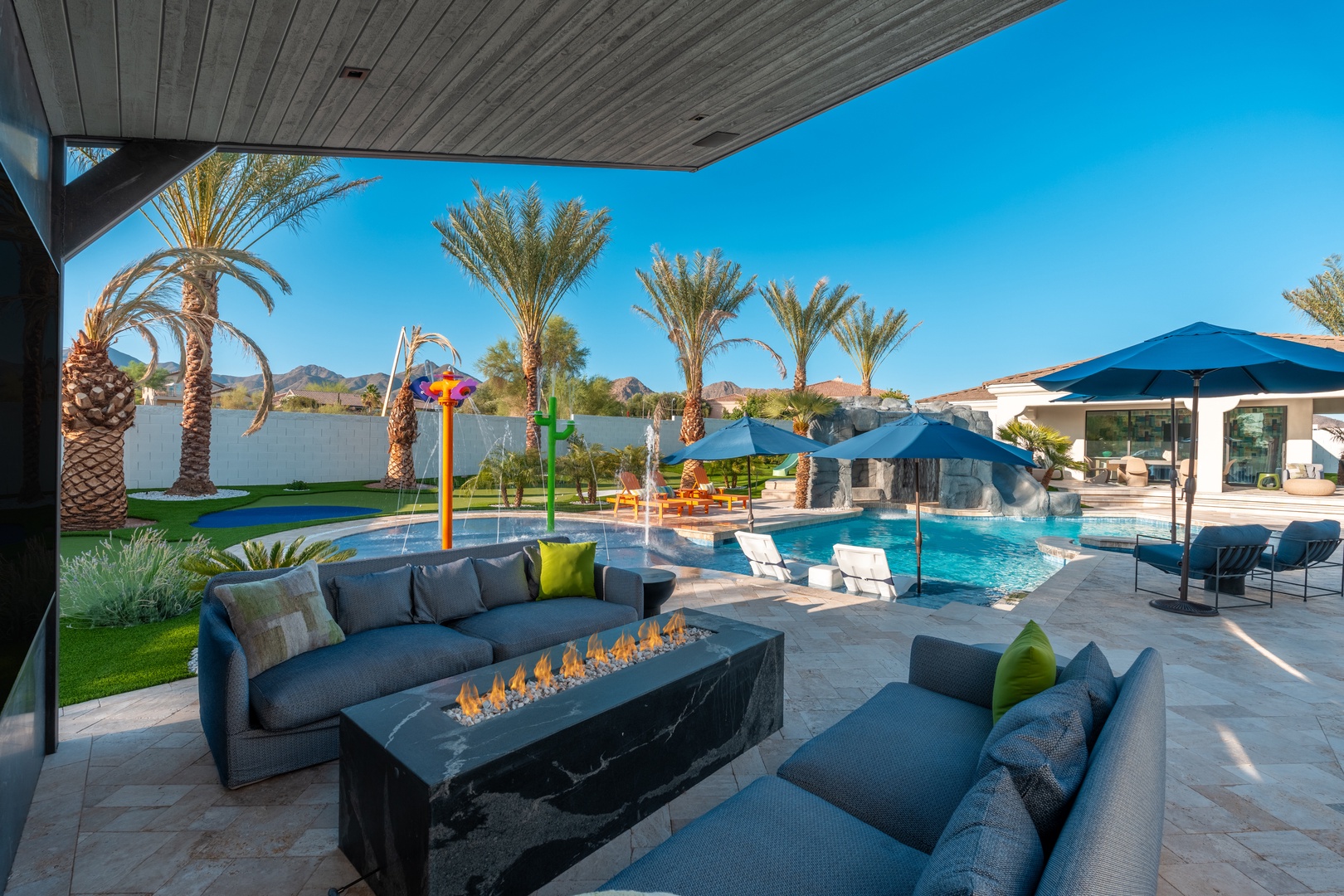 Gather around the outdoor fire table and soak in the stunning desert views. Your private pool and splash area await under swaying palms, with loungers ready for sun-soaked afternoons.