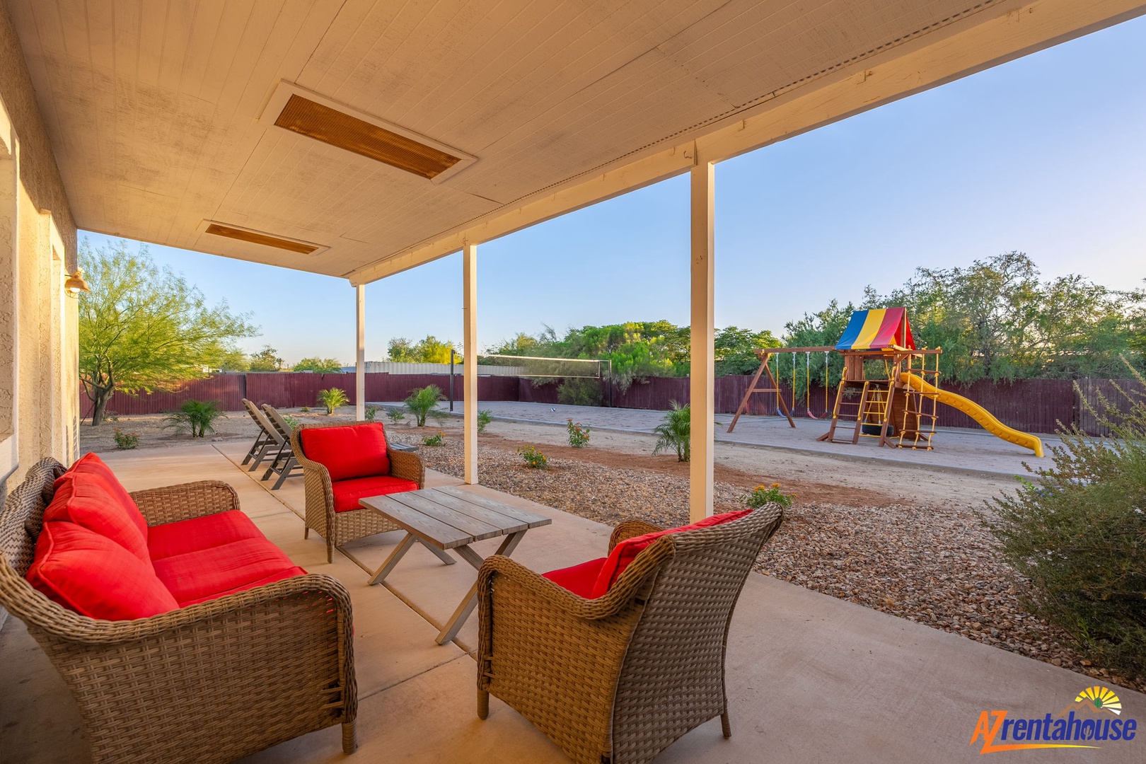 Relax on your covered patio with vibrant seating while the kids enjoy their colorful play set in the private desert-landscaped yard—perfect for morning coffee or evening unwind time.