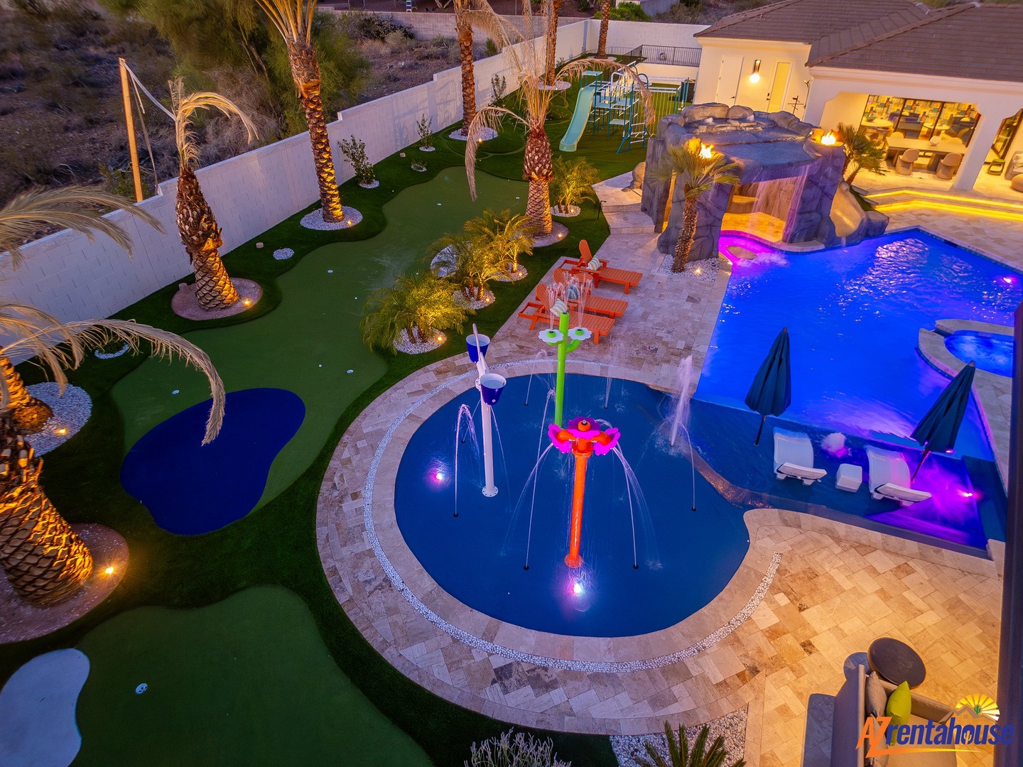 Spectacular backyard oasis featuring a circular splash pool with fountains, putting green, water slide, and twilight ambiance for unforgettable family fun.