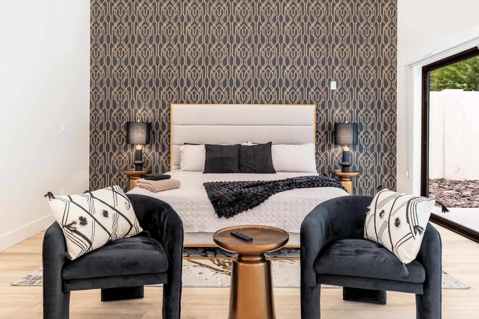 Sink into your plush king bed after a day exploring, with stylish armchairs and warm lighting creating your personal retreat.