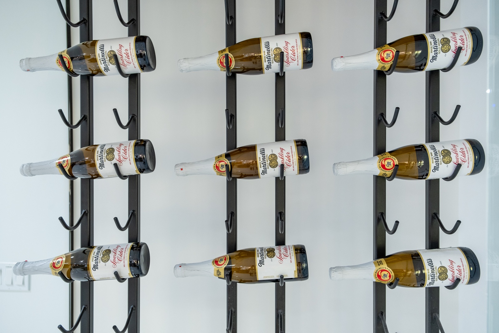 A sleek wall-mounted rack displays a curated selection of bottled beverages, ready to complement your stay with refreshment and style.