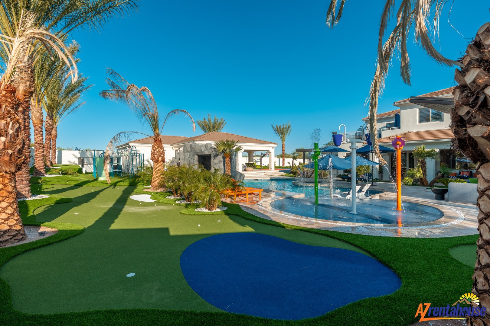 Resort features a colorful kids' water playground with splash zones and mini golf surrounded by palm trees and manicured lawns.