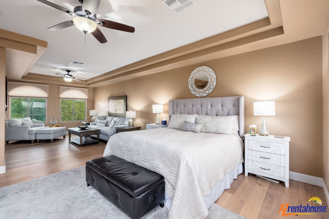 Unwind in your spacious master suite featuring a plush king bed, cozy seating area, and elegant ceiling fans for perfect comfort.