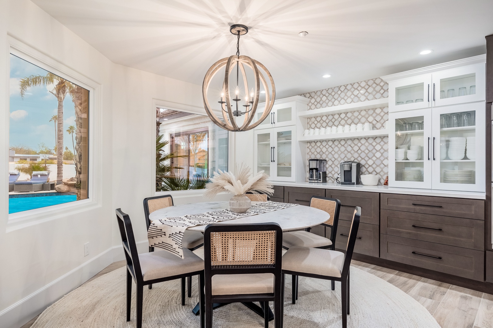 Gather around the marble-topped table, bathed in sunlight from the window overlooking the pool, while enjoying your morning coffee from the well-appointed kitchen.