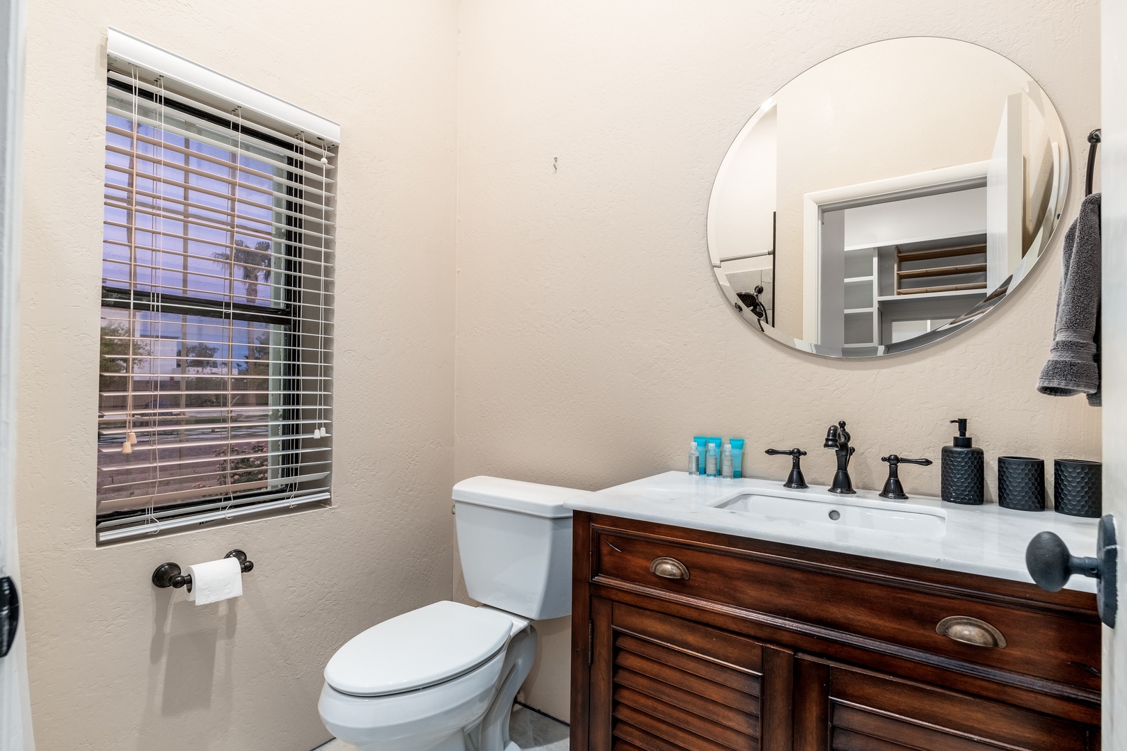 Step into your private bathroom with elegant fixtures, a warm wood vanity, and soft twilight views. Fresh towels and toiletries await your arrival.