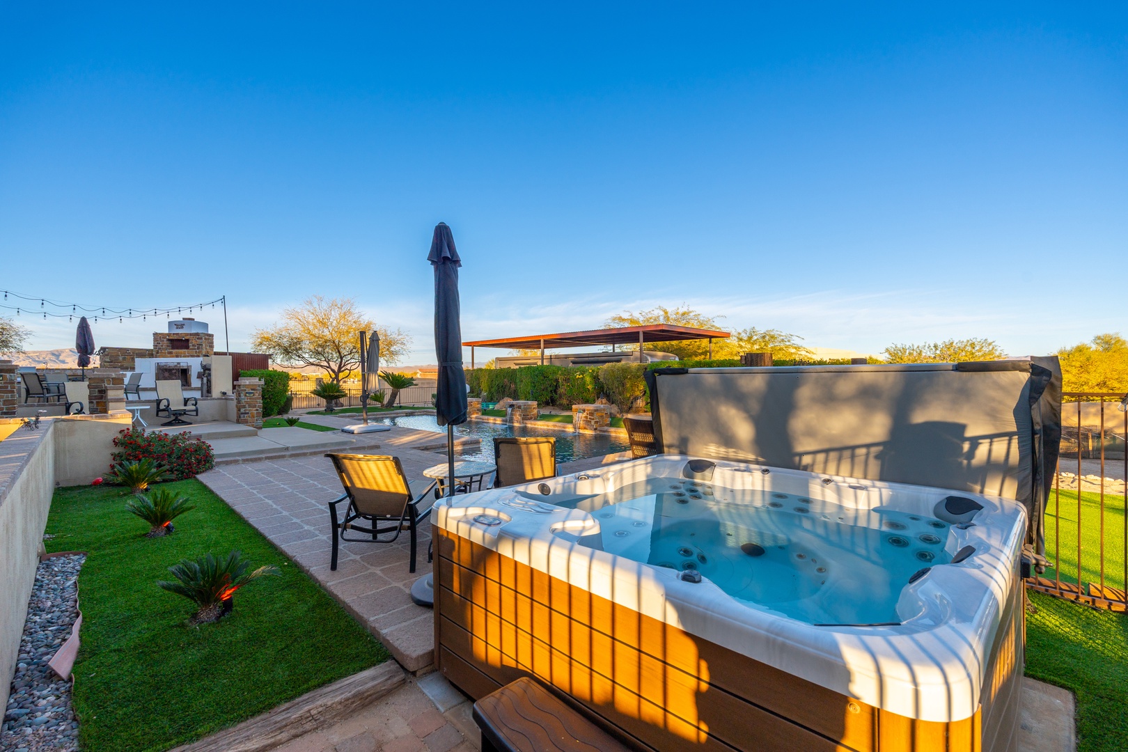 Slip into your private hot tub as golden sunlight warms the desert air, surrounded by lush landscaping and sweeping mountain views—pure relaxation awaits.