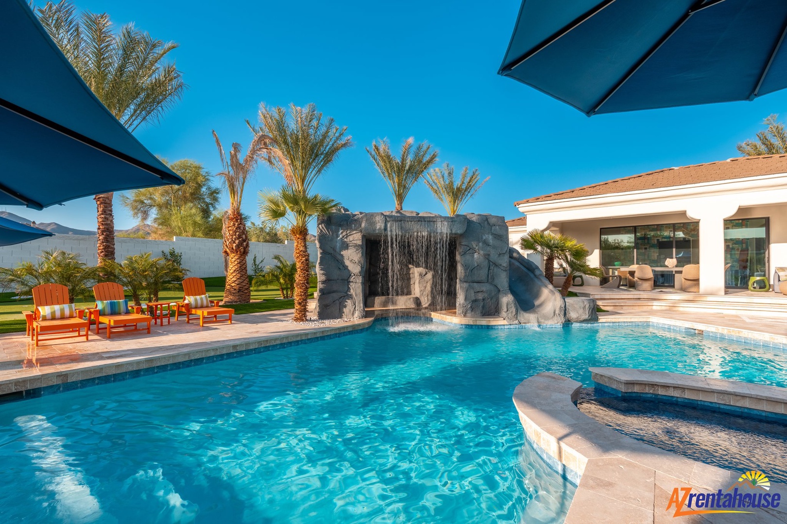 Dive into your private oasis featuring a stunning waterfall, spa, and poolside lounging under swaying palms.