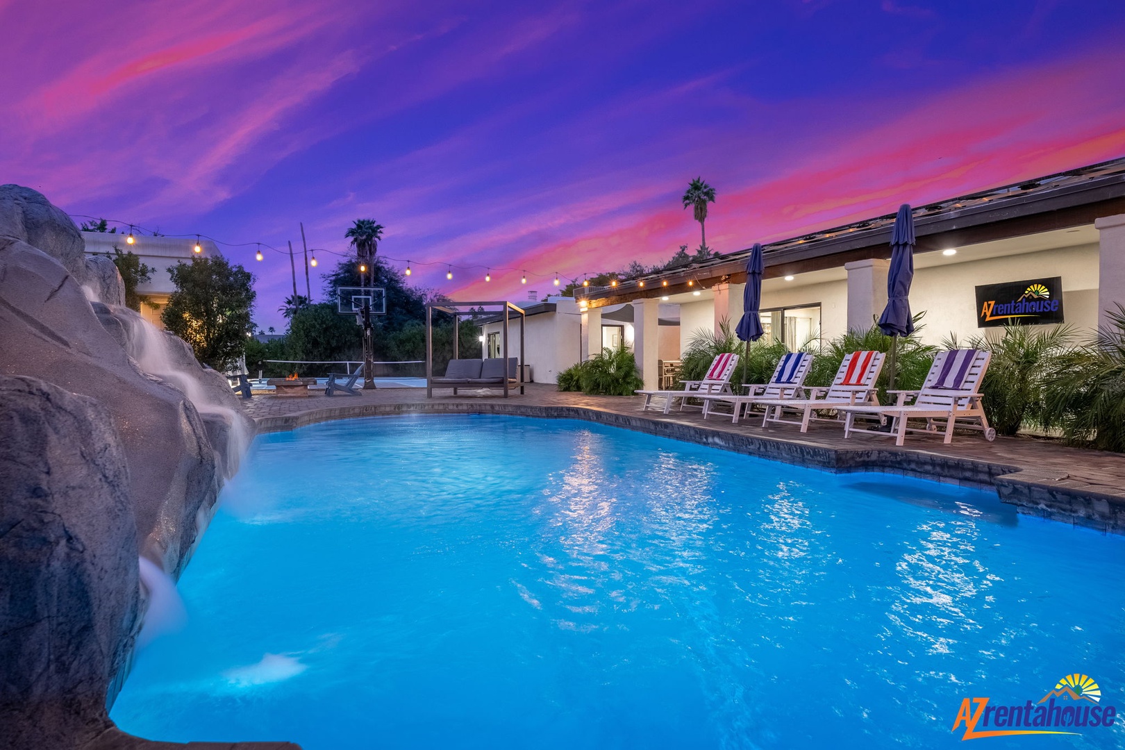 Stunning purple sunset backdrop illuminates the property's sparkling pool area and modern architecture.