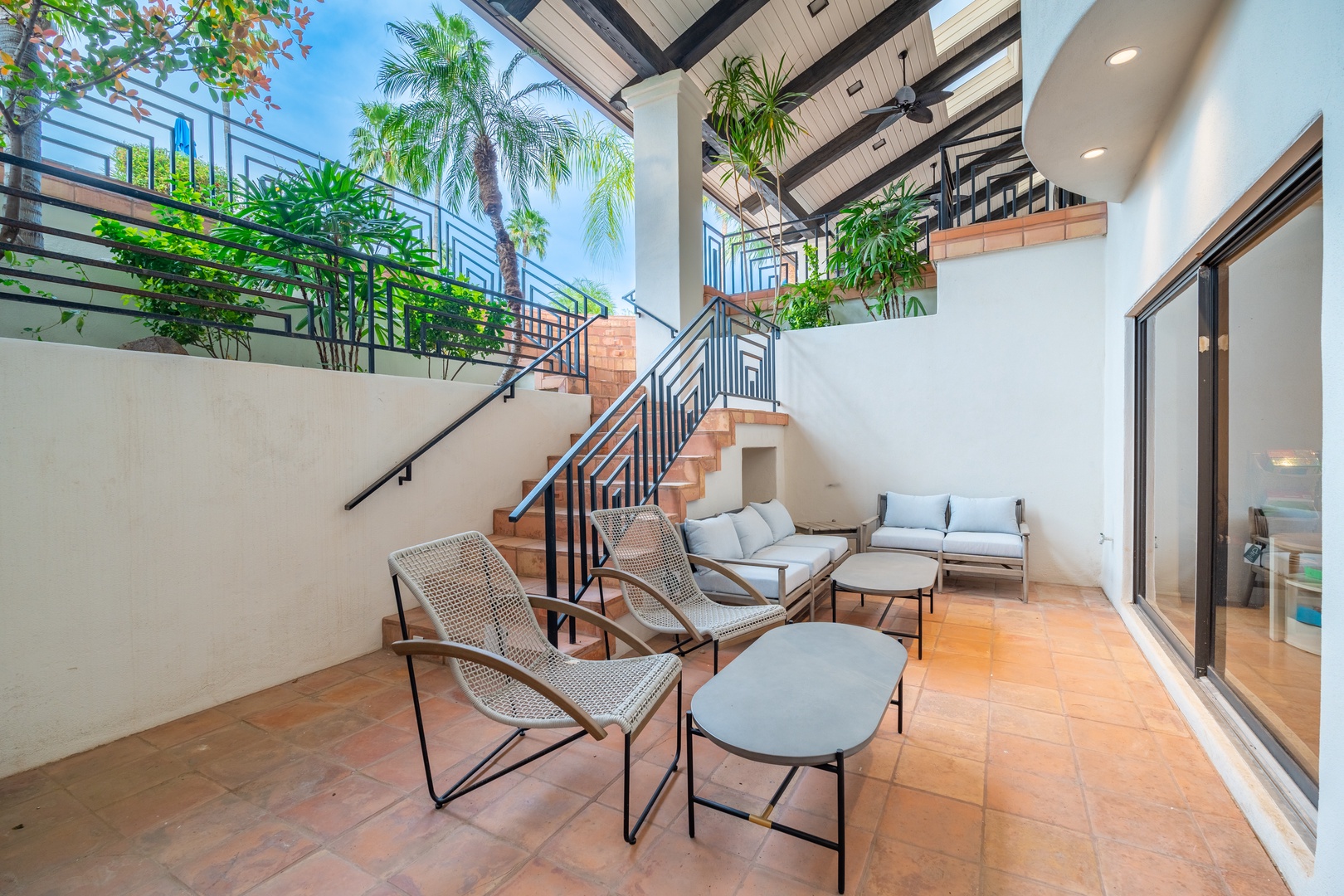 Your private patio invites you to lounge beneath tropical palms and open sky, blending indoor elegance with breezy outdoor comfort—perfect for morning coffee or evening relaxation.
